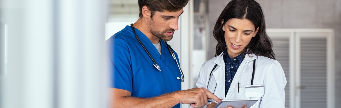 Arzt in blauem Kittel mit Ärztin in weißem Kittel, in Besprechung